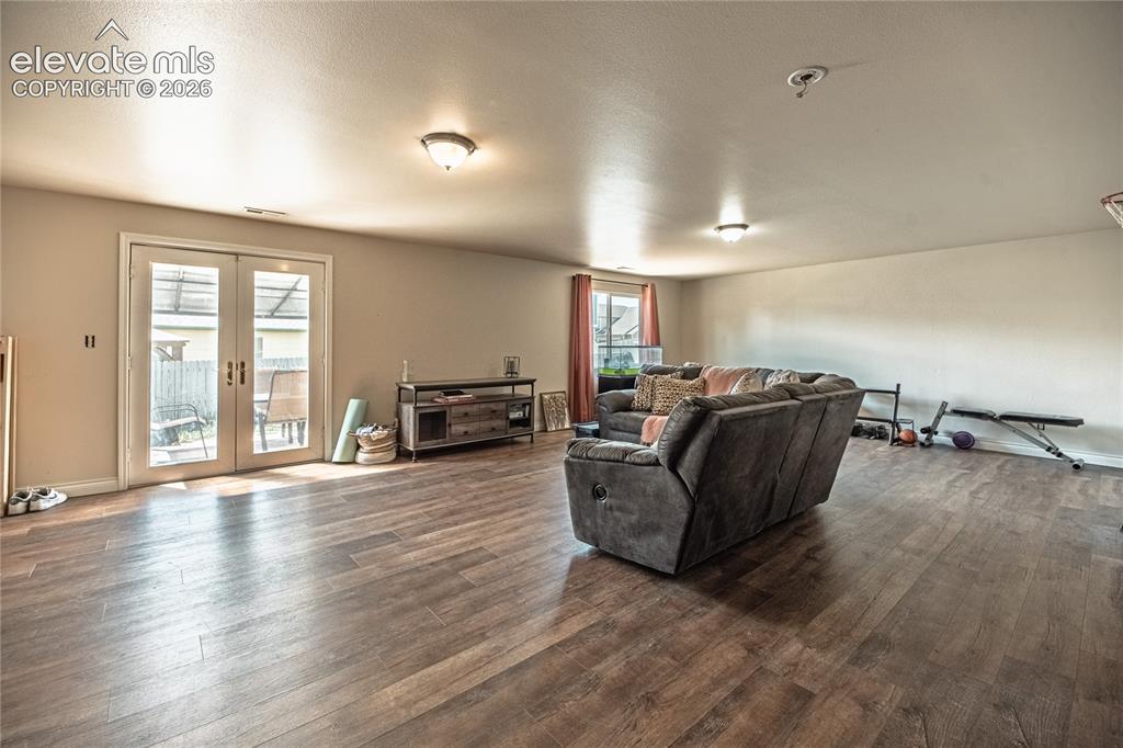 Image 36 of 48: Spacious room featuring wood-finish flooring, light-toned walls, and recess