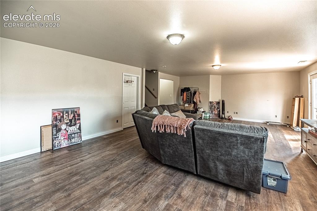 Image 38 of 48: Spacious room featuring wood-finish flooring, neutral-toned walls, and rece