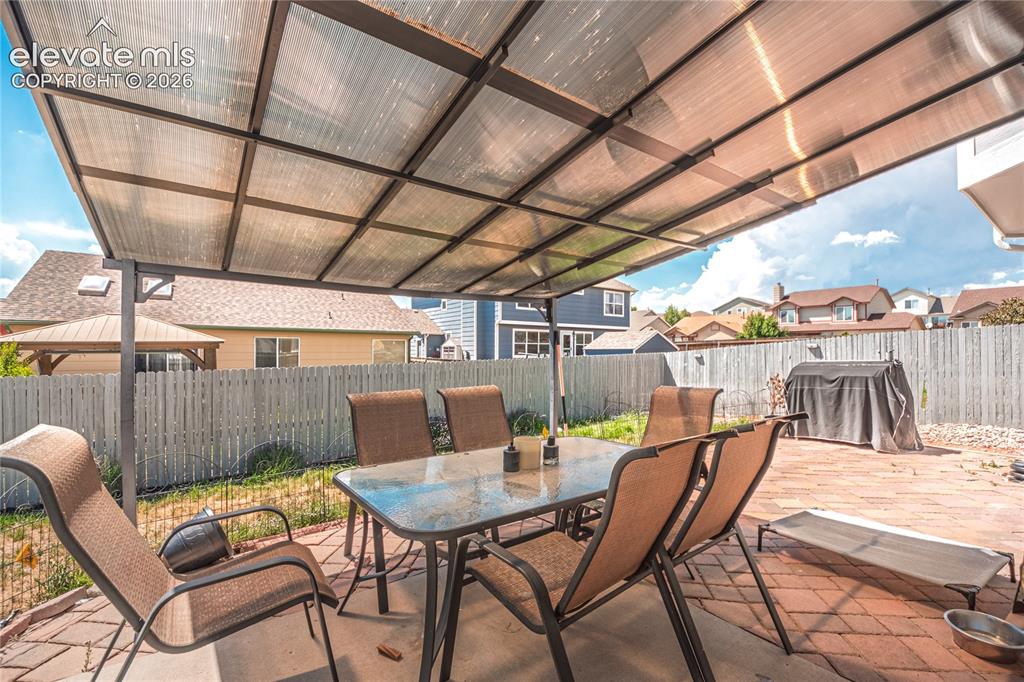 Image 39 of 48: Patio featuring a translucent panel cover, brick paver flooring, and a priv