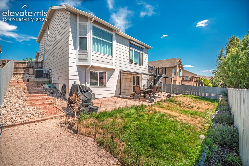 Image 41 of 48: Rear exterior featuring light-colored siding, a bay window, and a ground-le
