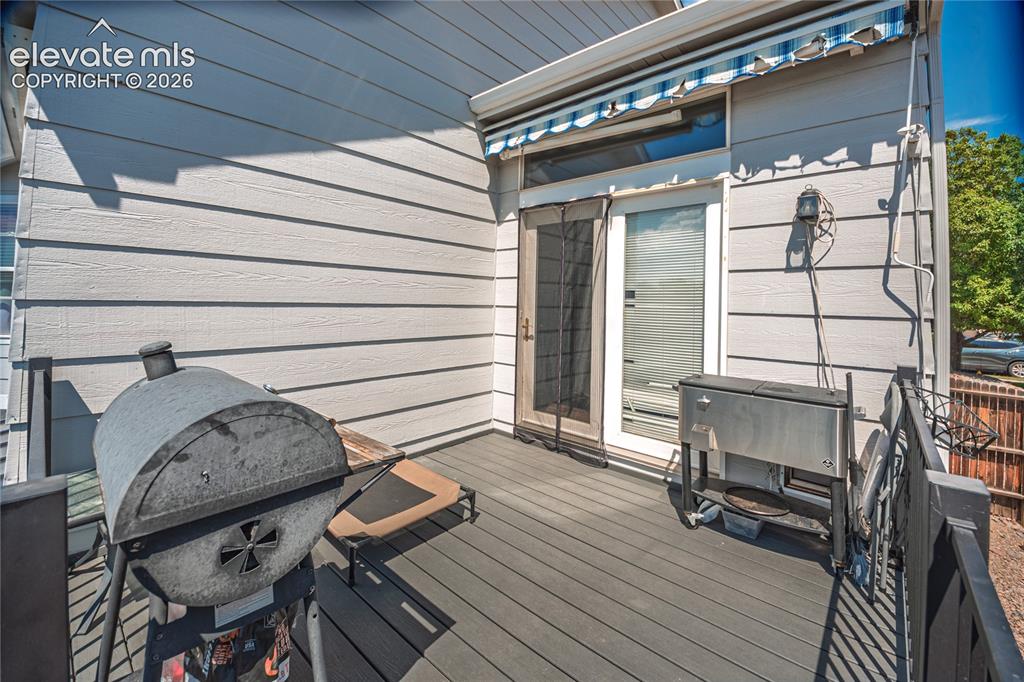 Image 43 of 48: Expansive outdoor deck featuring composite decking, white horizontal siding