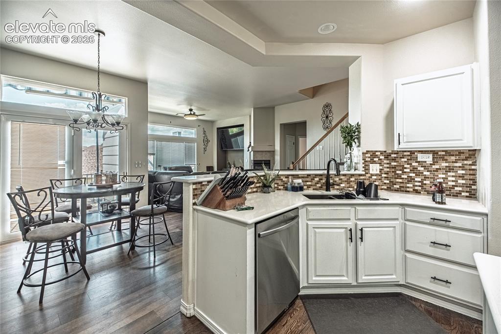 Image 9 of 48: Kitchen featuring white cabinetry, a mosaic tile backsplash, and a stainles