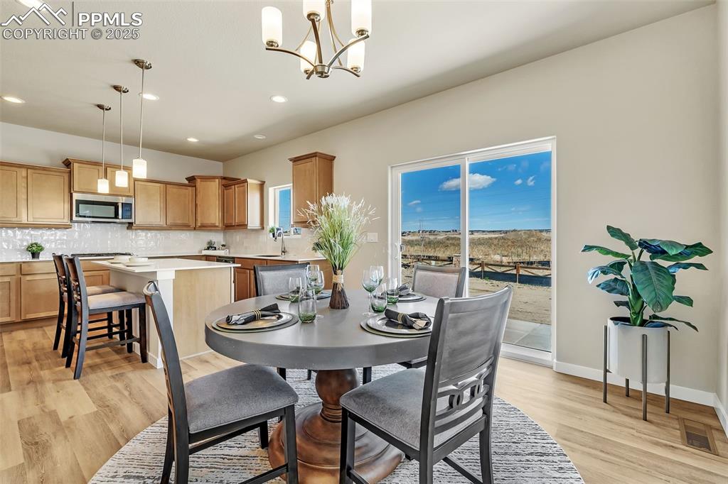Image 10 of 46: Dining area with recessed lighting, a chandelier, and light wood finished f