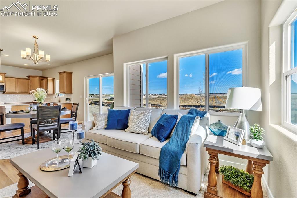 Image 11 of 46: Living room featuring a chandelier, light wood-type flooring, and recessed 