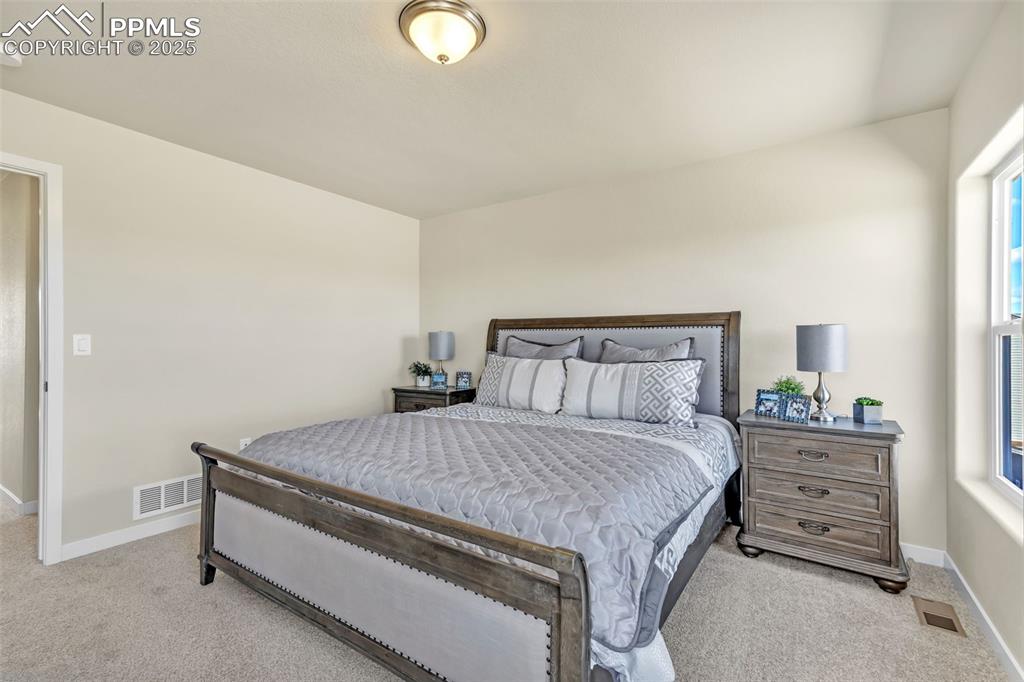 Image 27 of 46: Bedroom with baseboards and light carpet