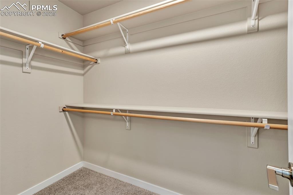 Image 32 of 46: Walk in closet with light colored carpet