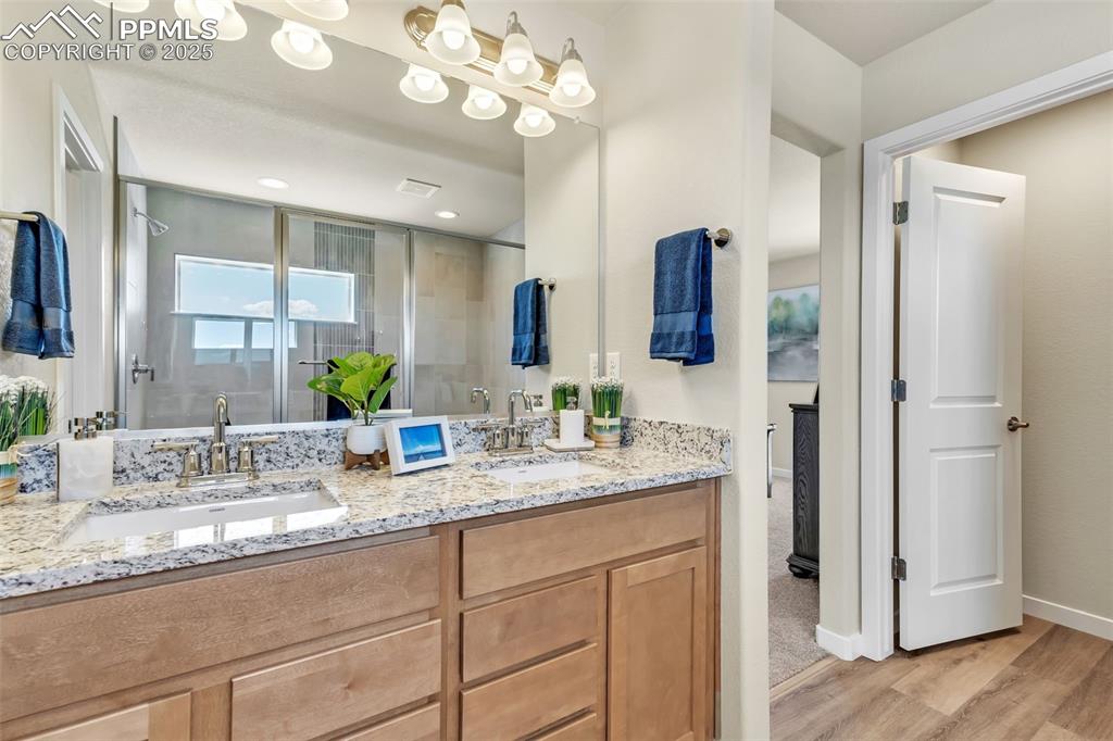 Image 34 of 46: Bathroom with a shower stall, double vanity, and light wood-type flooring