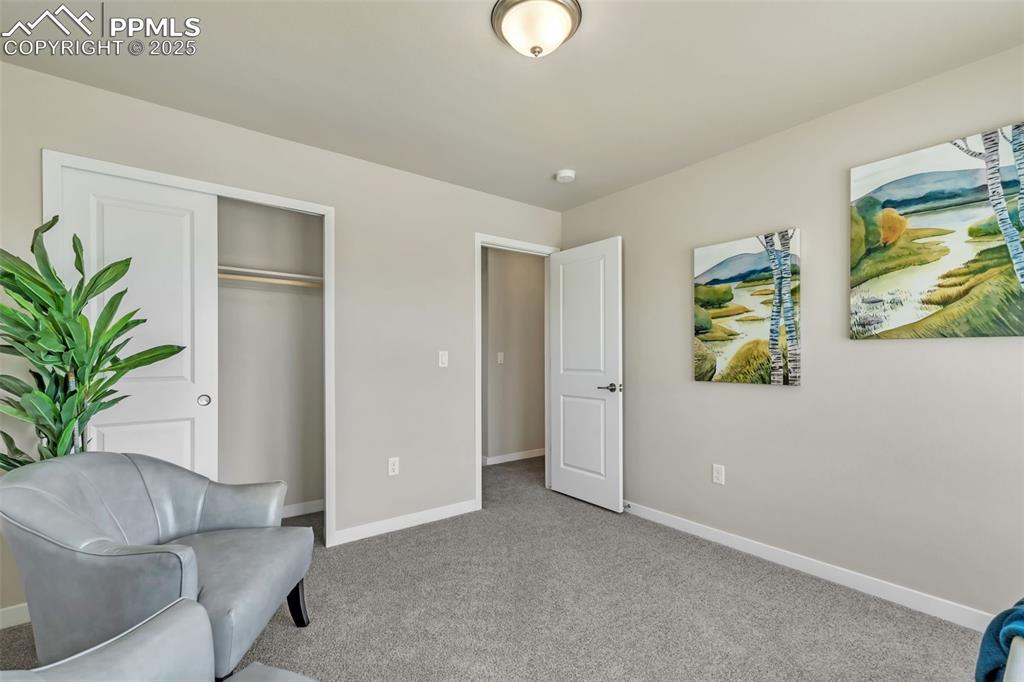 Image 37 of 46: Living area with light colored carpet and baseboards