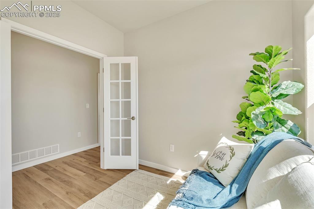 Image 5 of 46: Sitting room with wood finished floors and baseboards