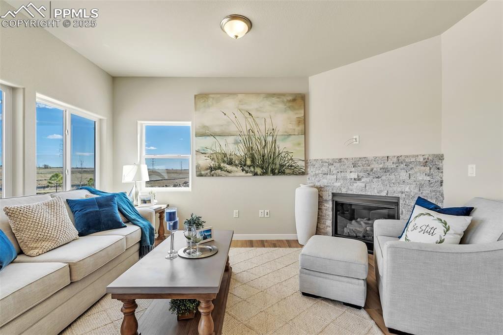 Image 9 of 46: Living room with wood finished floors and a stone fireplace