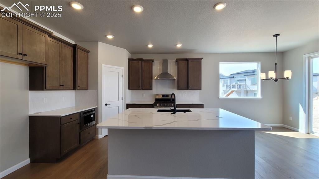 Image 6 of 23: Kitchen with quartz countertops, pantry, huge island providing additional s