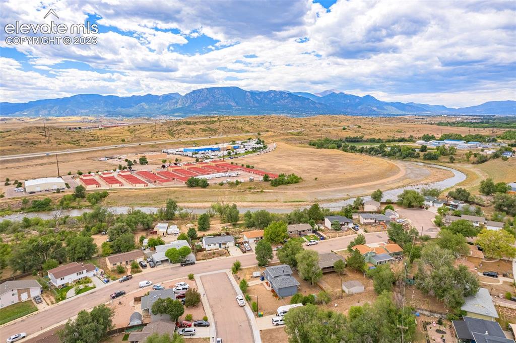 Image 42 of 43: Mountain backdrop with a winding river and established neighborhood