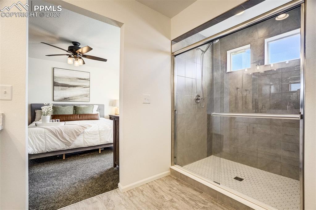 Image 18 of 42: Oversized standing shower with windows & tile surround. 