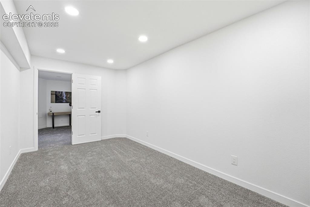 Image 14 of 36: Spacious room with new gray carpeting, crisp white walls, and recessed ligh