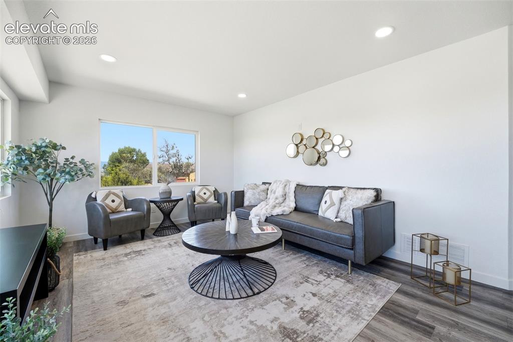 Image 2 of 36: Spacious living area featuring ample natural light, recessed lighting, wood