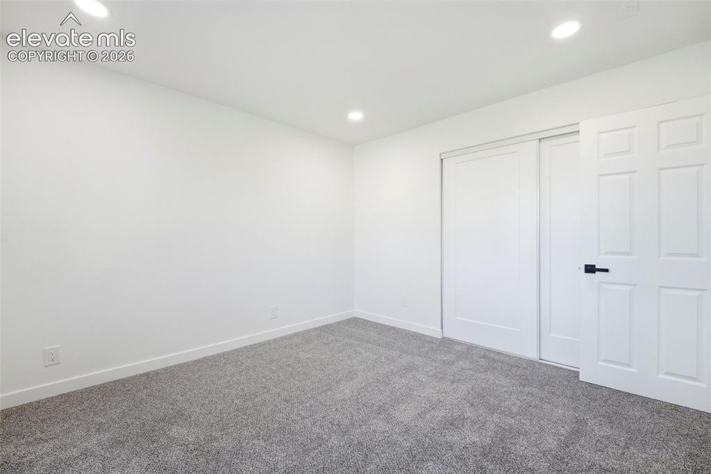 Image 20 of 36: Interior room featuring recessed lighting, light gray carpeting, white base