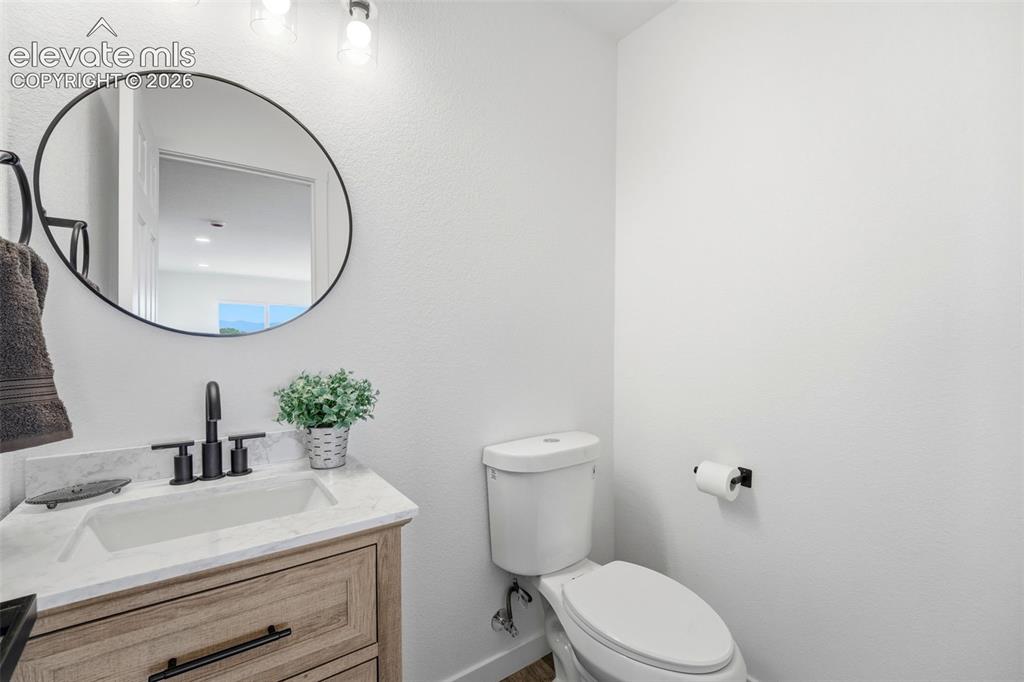 Image 26 of 36: Modern bathroom featuring a wood-finish vanity with a white countertop and