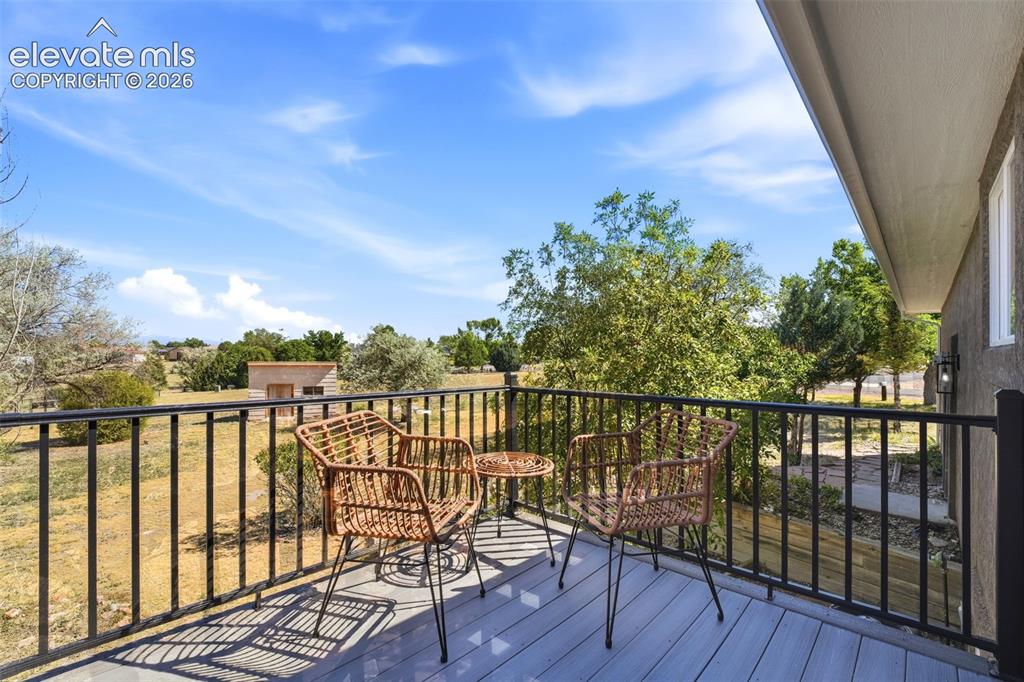 Image 28 of 36: Outdoor balcony featuring composite decking, black metal railing, and an ex