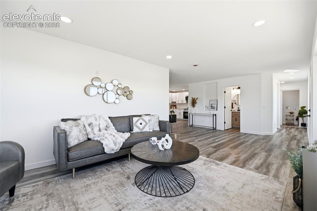 Image 3 of 36: Spacious interior featuring recessed lighting, wood-finish flooring, and wh