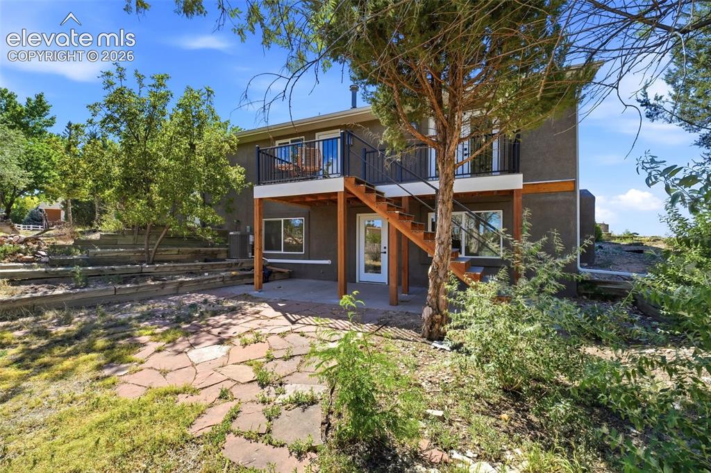 Image 30 of 36: Exterior featuring a stucco finish, a second-story balcony with black metal
