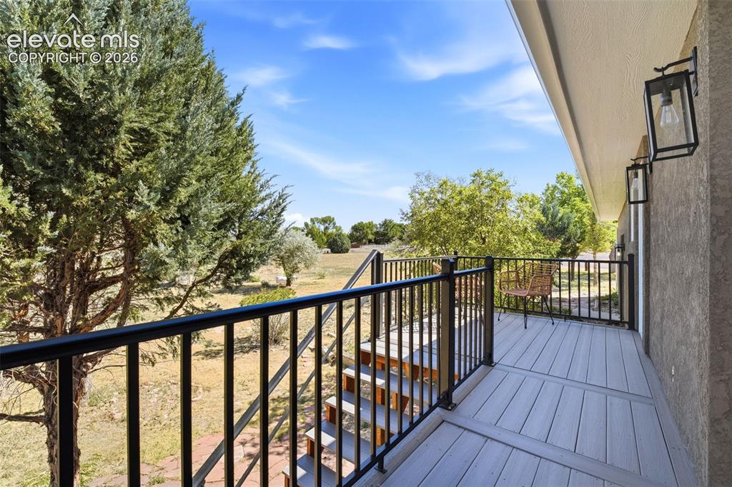 Image 33 of 36: Exterior balcony featuring a composite deck, black metal railings, and dual