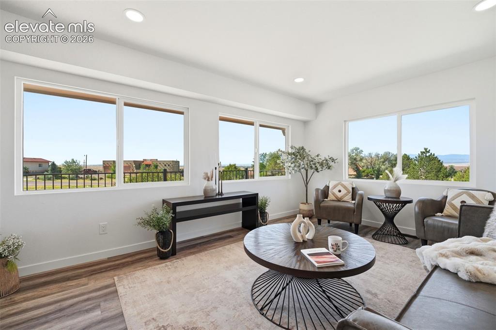 Image 4 of 36: Bright living area featuring expansive windows, wood-finish flooring, reces