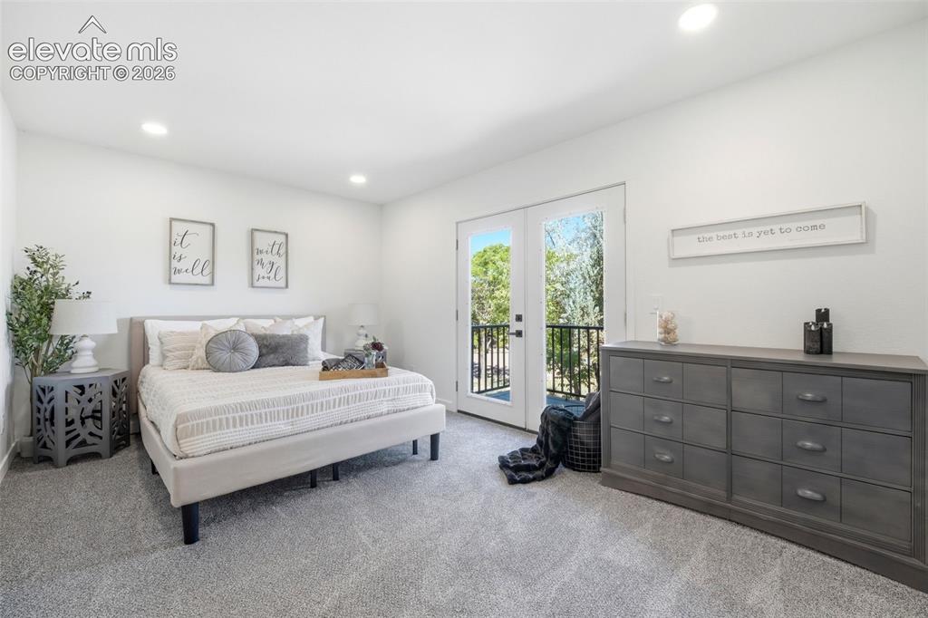 Image 9 of 36: Bedroom featuring a private balcony through double French doors, recessed l