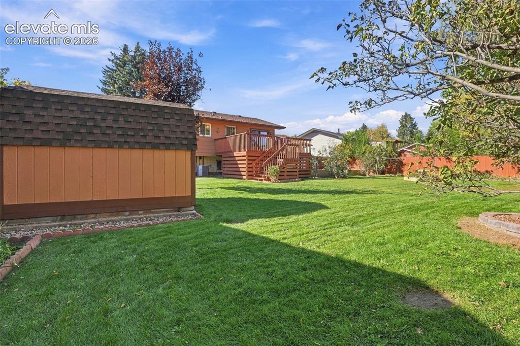 Image 10 of 42: Expansive backyard featuring a manicured lawn, detached storage structure w