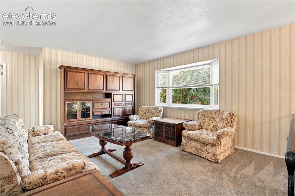 Image 12 of 42: Built-in wall-to-wall cabinetry, bay window, and wallpapered walls