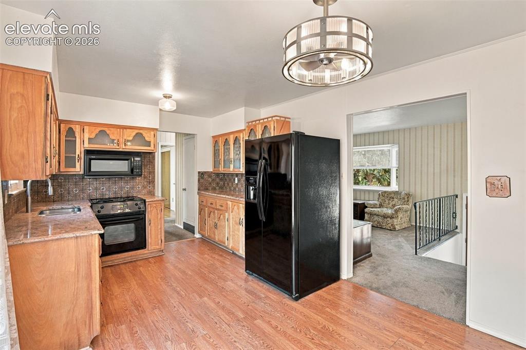 Image 16 of 42: Kitchen featuring wood cabinetry, stone-finish countertops, tile backsplash