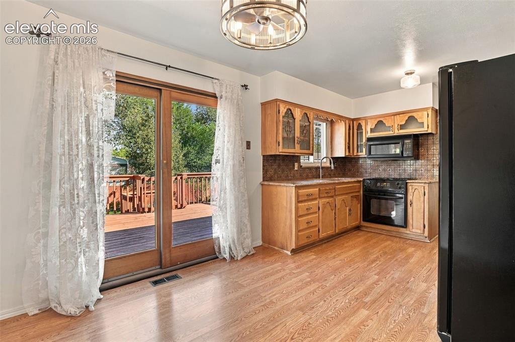 Image 3 of 42: Kitchen featuring wood cabinetry, tiled backsplash, integrated microwave, w