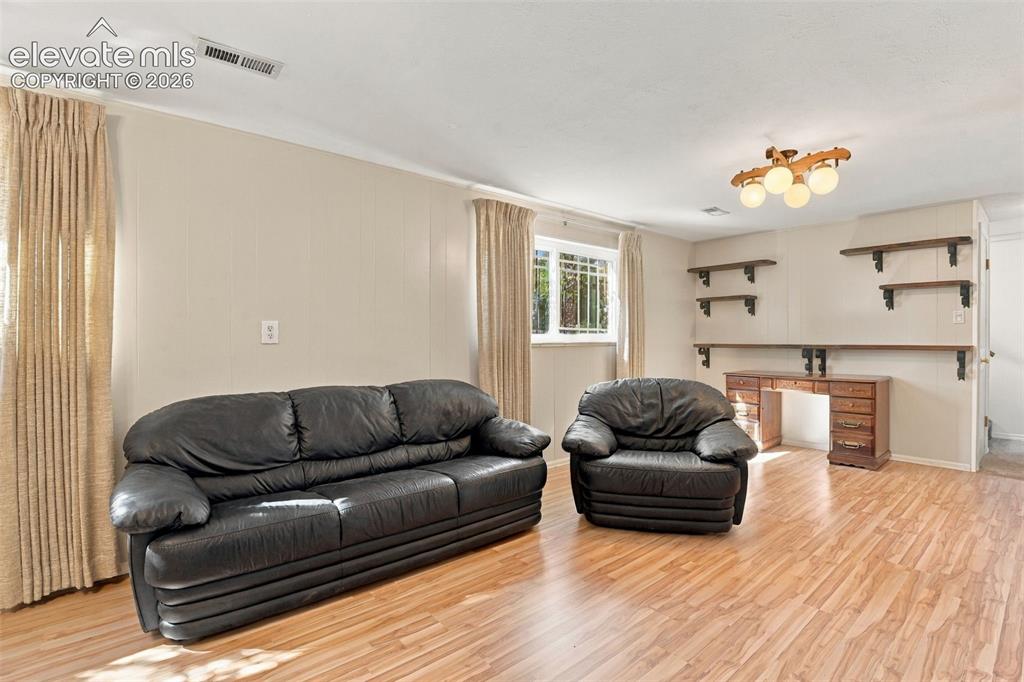 Image 31 of 42: Wood-finish flooring, multi-light ceiling fixture, and built-in wall shelvi