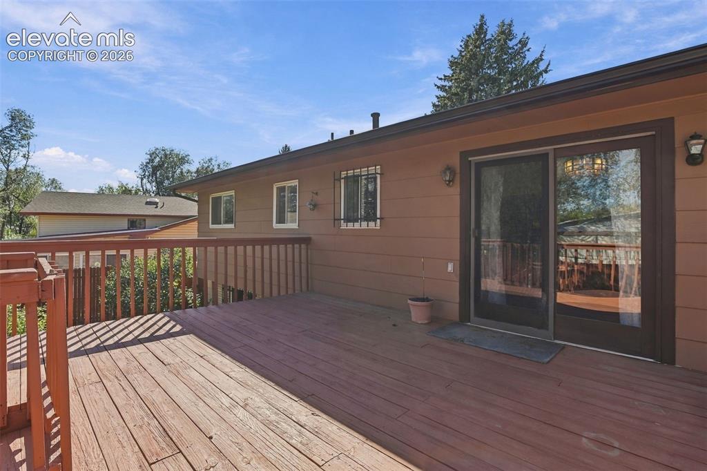 Image 39 of 42: Expansive wood deck with a matching railing, horizontal exterior siding, sl