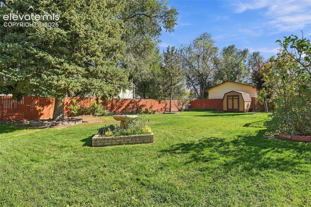 Image 41 of 42: Expansive backyard featuring a mature canopy of trees, a wood-slat privacy