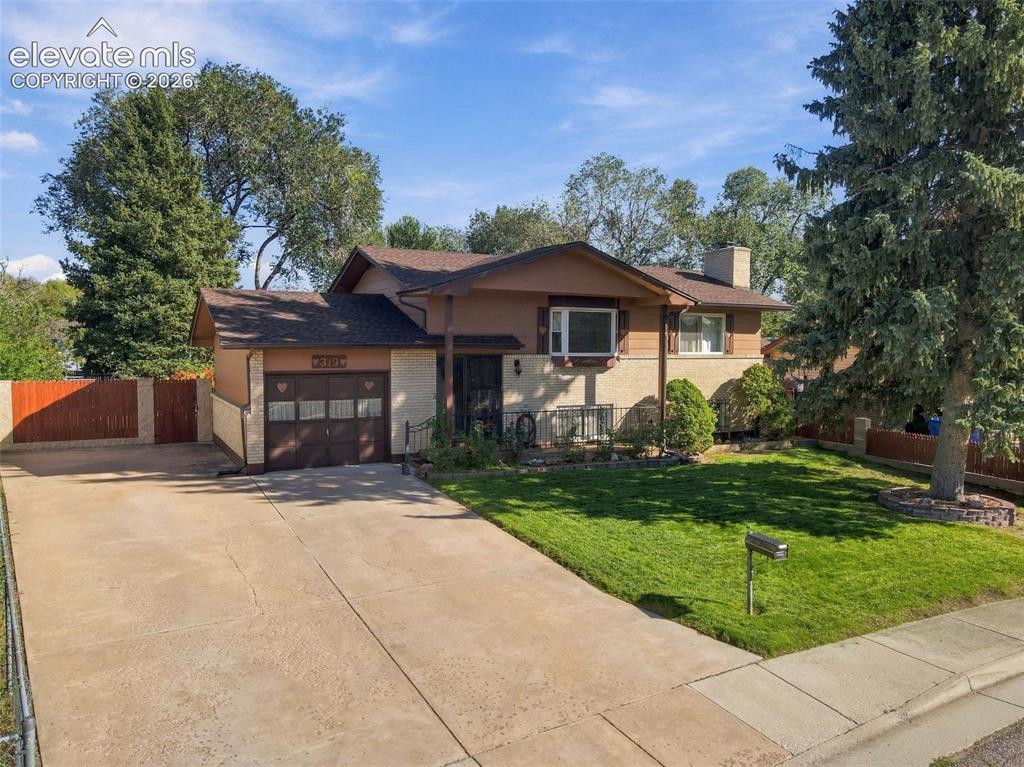 Image 8 of 42: Split-level exterior featuring a combination of brick and wood-paneled sidi