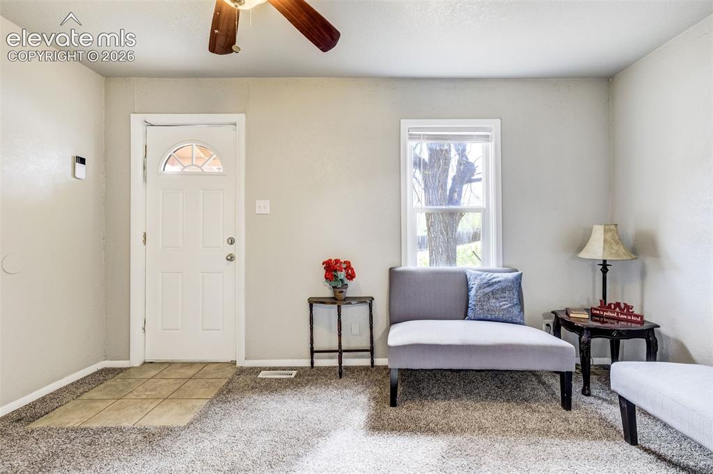 Image 11 of 46: Entryway featuring a white paneled door with an arched glass insert, tile f