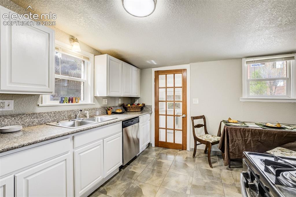 Image 16 of 46: Kitchen featuring white shaker-style cabinetry, granite-finish countertops,