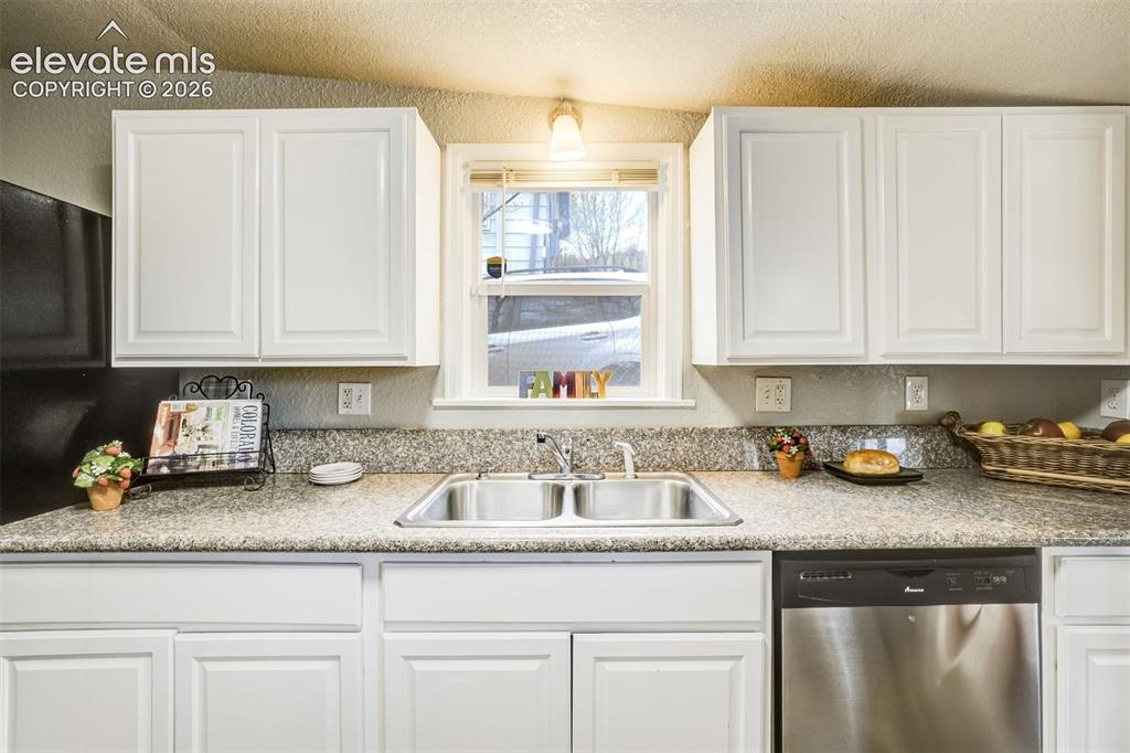 Image 17 of 46: Contemporary kitchen featuring white cabinetry and light-toned countertops
