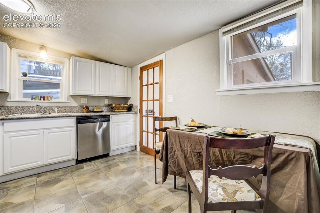 Image 24 of 46: Kitchen featuring white cabinetry, light-toned countertops, and a stainless