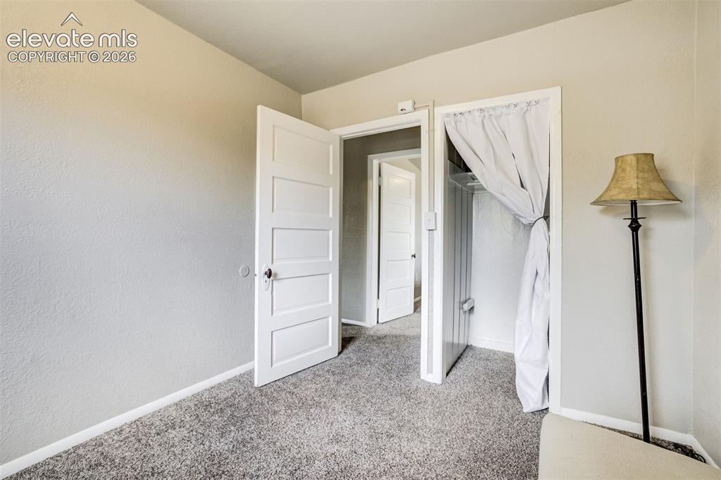 Image 30 of 46: Interior room featuring light gray walls, gray carpeting, a paneled white d