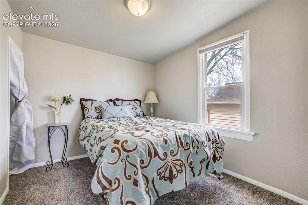Image 32 of 46: Bedroom featuring neutral wall paint, textured ceiling, light gray carpet f