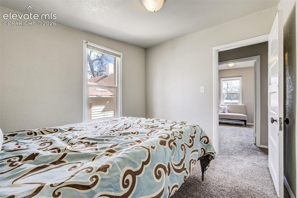 Image 35 of 46: Bedroom featuring neutral wall paint, a double-hung window, textured carpet
