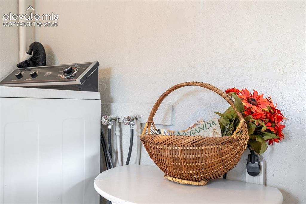 Image 39 of 46: Laundry appliance featuring top-mounted controls and connected water lines