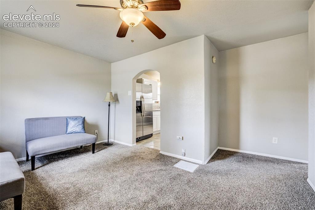 Image 9 of 46: Carpeted living space with a ceiling fan light fixture