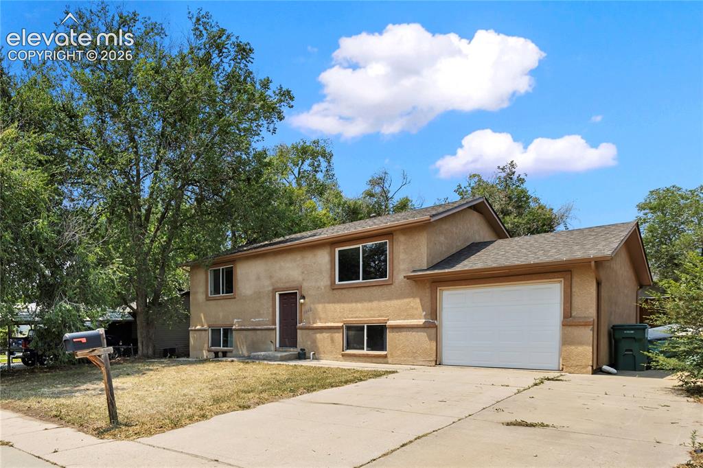 Image 1 of 23: Inviting front elevation with mature shade tree and attached garage