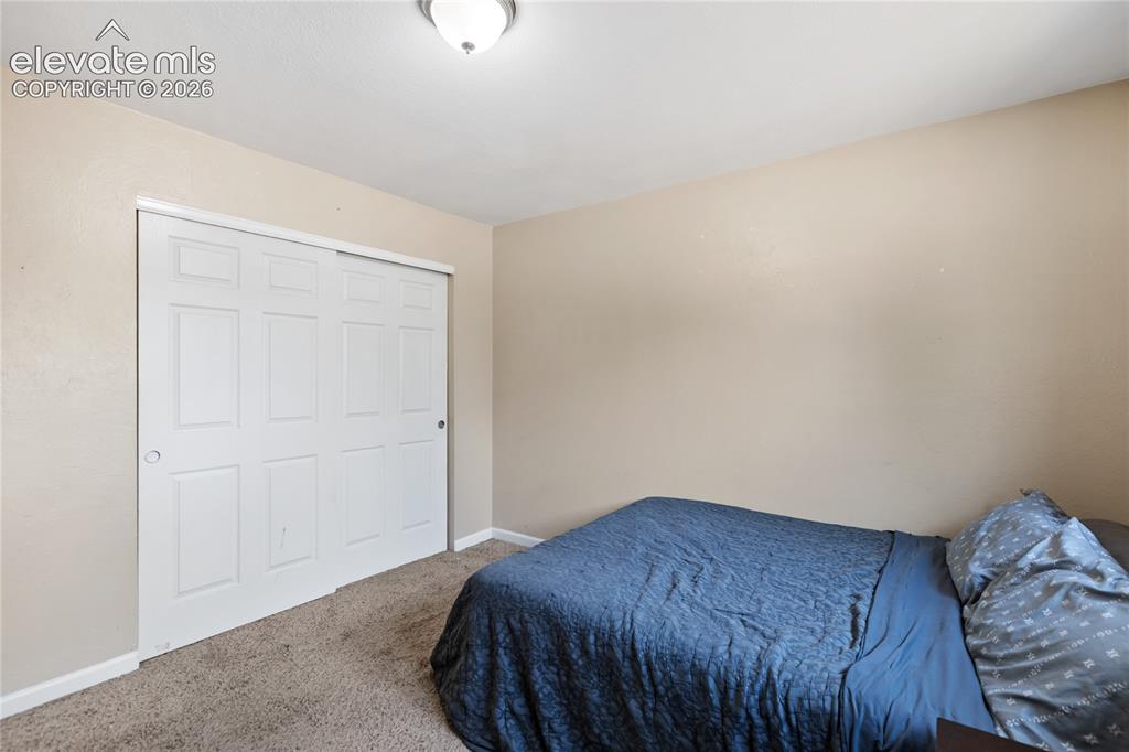 Image 18 of 23: Main-level bedroom with natural light