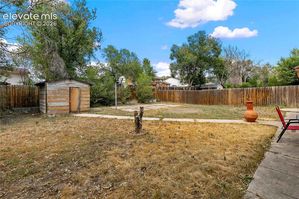 Image 22 of 23: Expansive backyard with storage shed