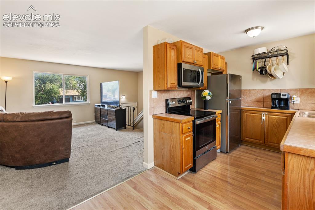 Image 4 of 23: Kitchen opens to adjacent dining and living areas
