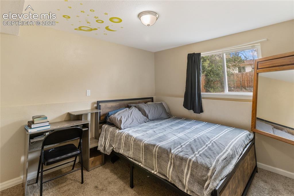 Image 7 of 23: Carpeted bedroom with natural light