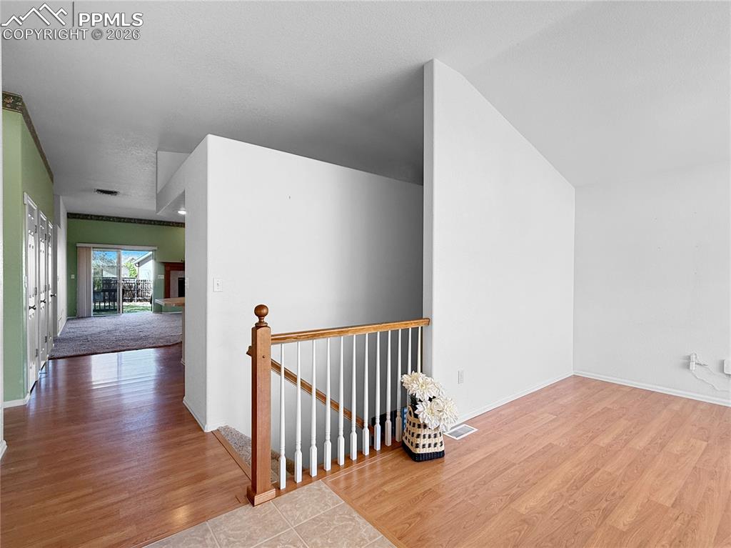 Image 5 of 46: Looking from entrance, past formal dining, basement stairs and main floor e